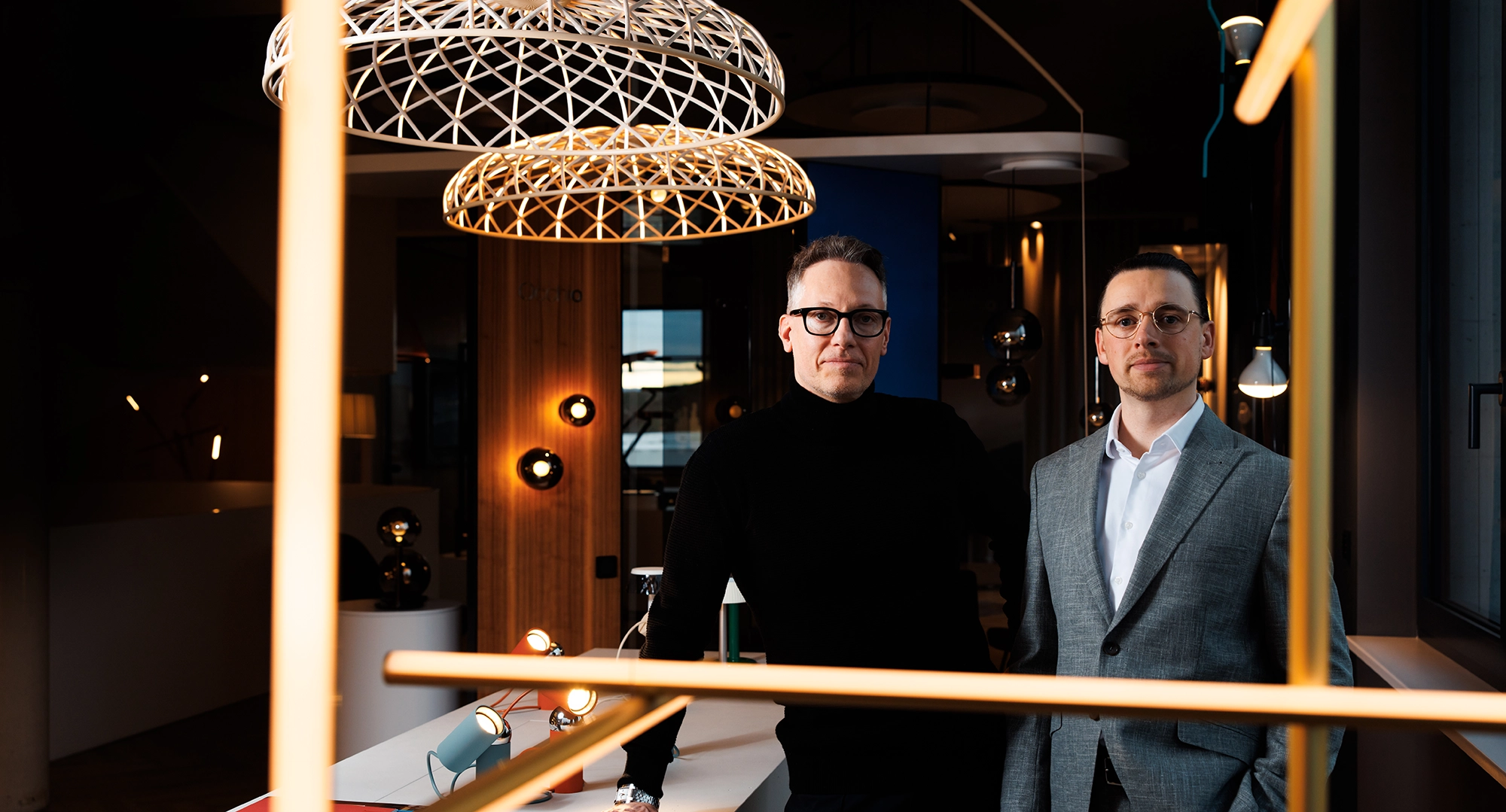 Roman und Georg stehen in einem dunklen Raum mit goldenen Designelementen
